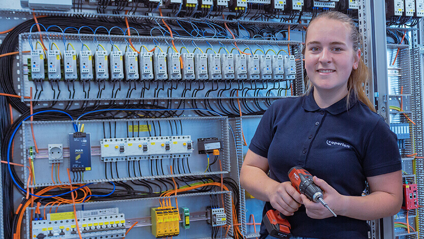 Coperion mechatronics egineer with tools in front of control cabinet