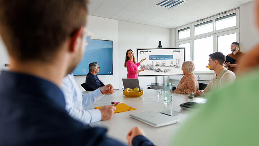 Coperion employee showing presentation in team meeting on screen