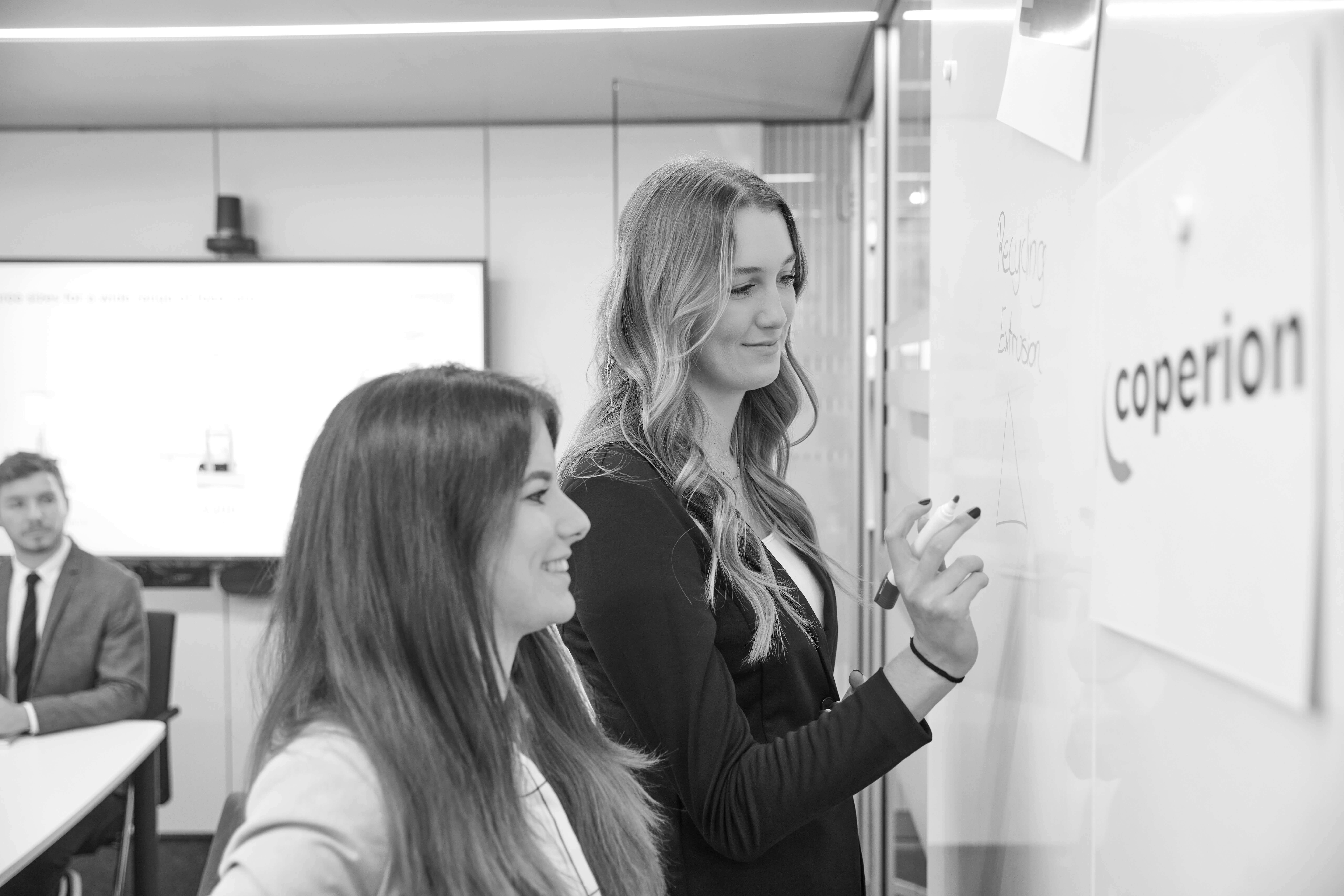 Auszubildende am Whiteboard black and white