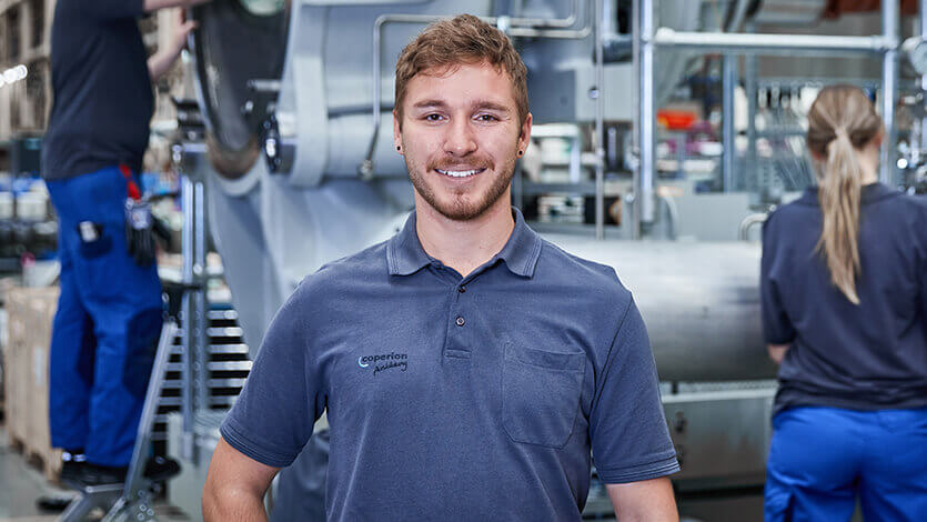 Coperion industrial mechanic standing in front of Water Ring Pelletizer